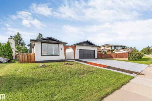 Contemporary ranch-style residence featuring white siding and a prominent dark roofline - 5512 150 Avenue, Edmonton, AB 