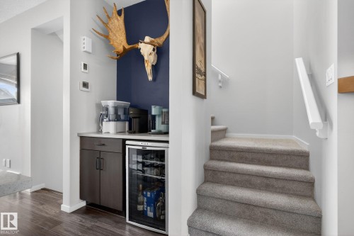 Integrated beverage station with dark cabinetry, light countertop, and built-in mini-refrigerator - 3456 Cutler Crescent, Edmonton, AB - Indoor Photo Showing Other Room