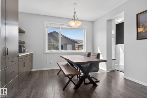 Dining area featuring wood-finish flooring, a pendant light fixture, and a large window - 3456 Cutler Crescent, Edmonton, AB - Indoor Photo Showing Dining Room
