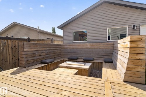 Wood-finish decking with built-in seating featuring a central fire pit area - 3456 Cutler Crescent, Edmonton, AB - Outdoor With Deck Patio Veranda With Exterior