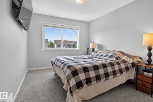 Spacious room featuring neutral paint, gray carpet, a ceiling light fixture, and a large window with white trim - 3456 Cutler Crescent, Edmonton, AB - Indoor Photo Showing Bedroom