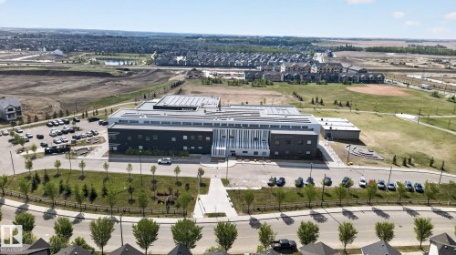 Modern institutional building featuring a multi-tone facade with dark grey and white paneling - 3456 Cutler Crescent, Edmonton, AB - Outdoor With View