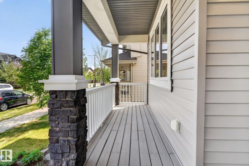 Front porch featuring gray plank flooring, white railing, and a stone-clad column base - 3456 Cutler Crescent, Edmonton, AB - Outdoor With Deck Patio Veranda With Exterior