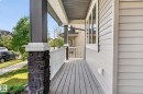 Front porch featuring gray plank flooring, white railing, and a stone-clad column base - 3456 Cutler Crescent, Edmonton, AB  - Outdoor With Deck Patio Veranda With Exterior 