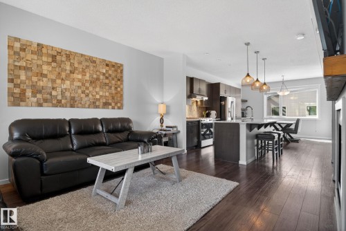 Open-concept living space featuring wood-finish flooring, recessed lighting, and a modern kitchen - 3456 Cutler Crescent, Edmonton, AB - Indoor Photo Showing Living Room