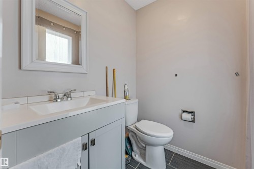 Bathroom featuring a contemporary gray vanity with a built-in sink, chrome faucet, and white countertop - 24 1651 46 Street, Edmonton, AB 