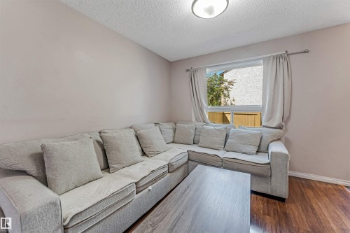 Living area with wood-finish flooring and light-toned walls - 24 1651 46 Street, Edmonton, AB 
