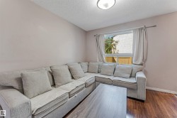 Living area with wood-finish flooring and light-toned walls - 