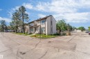 Multi-unit residential property with light-colored siding and dark trim accents - 24 1651 46 Street, Edmonton, AB 
