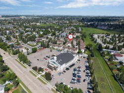 Aerial view of the neighborhood featuring a dense residential area, mature trees, and open green spaces - 