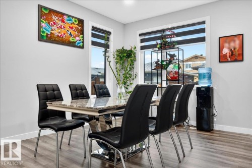Dining area featuring wood-finish flooring, light gray wall paint, and white trim - 18139 75 Street, Edmonton, AB 