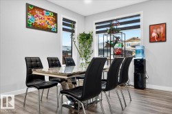 Dining area featuring wood-finish flooring, light gray wall paint, and white trim - 