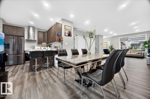 Open-concept living space featuring wood-finish flooring, recessed lighting, and a kitchen with stainless steel appliances - 18139 75 Street, Edmonton, AB 