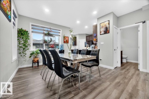 Dining space with wood-finish flooring, recessed lighting, and a large window with horizontal blinds - 18139 75 Street, Edmonton, AB 