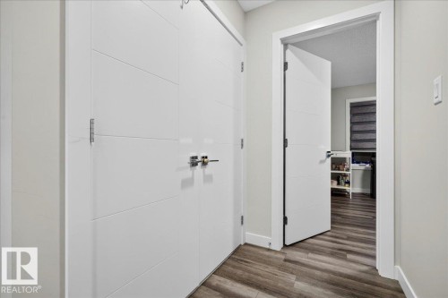 Hallway featuring wood-finish flooring, light gray wall paint, and white trim - 18139 75 Street, Edmonton, AB 