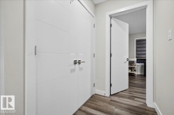 Hallway featuring wood-finish flooring, light gray wall paint, and white trim - 