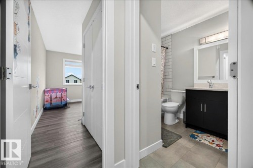 Hallway featuring wood-finish flooring and white interior doors - 18139 75 Street, Edmonton, AB 