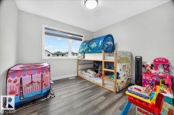 Light-filled room featuring wood-finish flooring, white baseboards, and a double window with exterior views - 