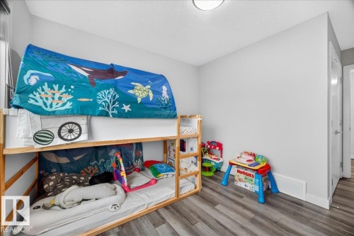 Room featuring light gray walls, wood-finish flooring, and a flush-mount ceiling light - 18139 75 Street, Edmonton, AB 