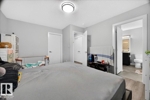 Interior room featuring light gray walls, wood-finish flooring, and a flush-mount ceiling light fixture - 18139 75 Street, Edmonton, AB 