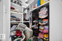 Built-in closet system with multiple white shelving units and hanging rods - 