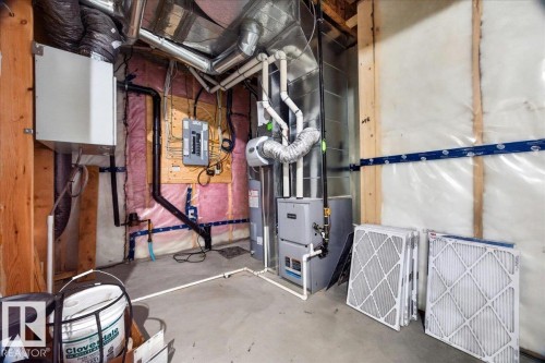 Utility space featuring a furnace, water heater, electrical panel, and exposed ductwork - 18139 75 Street, Edmonton, AB 
