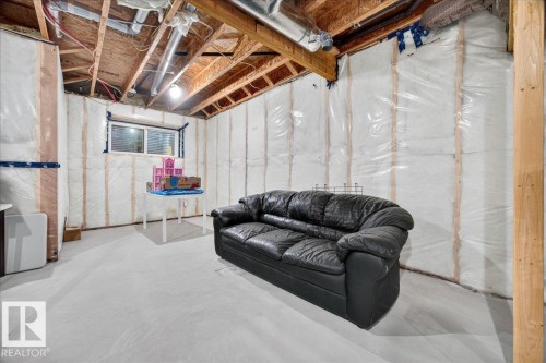 Unfinished basement featuring exposed wood joists and structural beams, insulated walls with vapor barrier, and a single window - 18139 75 Street, Edmonton, AB 