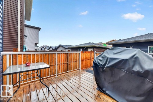 Spacious wood-finish deck with white railing, featuring a privacy fence and exterior siding - 18139 75 Street, Edmonton, AB 