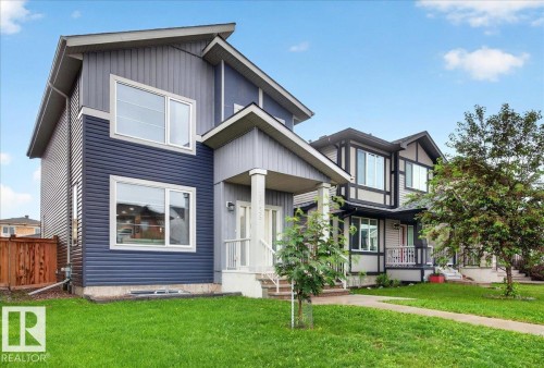 Modern two-story residence featuring multi-tone siding, prominent white-framed windows, and a covered entry with white pillars - 18139 75 Street, Edmonton, AB 