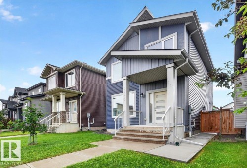 Modern two-story residence with a blue-gray siding exterior, a contrasting white front door, and a covered porch - 18139 75 Street, Edmonton, AB 