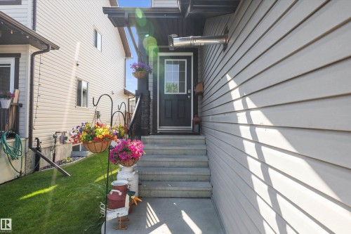 Concrete steps ascending to a dark-paneled door with an overhead awning - 25 Halladay Boulevard, Spruce Grove, AB - Outdoor