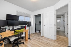 Light wood-finish flooring throughout this room, featuring a window with cellular shades - 