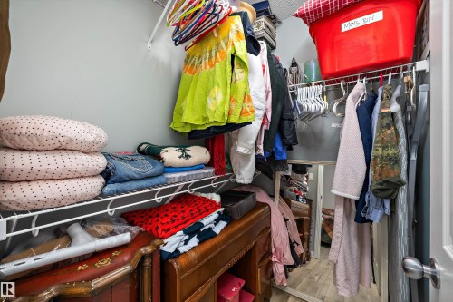 Closet featuring white wire shelving, overhead storage, and wood-finish flooring - 25 Halladay Boulevard, Spruce Grove, AB - Indoor With Storage