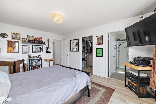 Bedroom featuring wood-finish flooring, white walls, and a contemporary ceiling light fixture - 25 Halladay Boulevard, Spruce Grove, AB - Indoor Photo Showing Bedroom