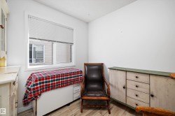 White window framing a multi-pane window with horizontal blinds, complemented by light wood-finish flooring - 