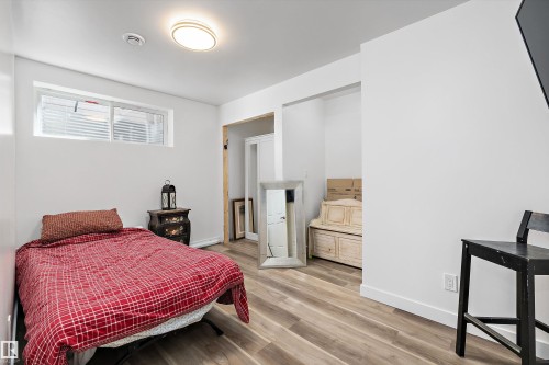 Room featuring wood-finish flooring, a contemporary flush-mount ceiling light, white baseboards, and a window with horizontal blinds - 25 Halladay Boulevard, Spruce Grove, AB - Indoor Photo Showing Bedroom