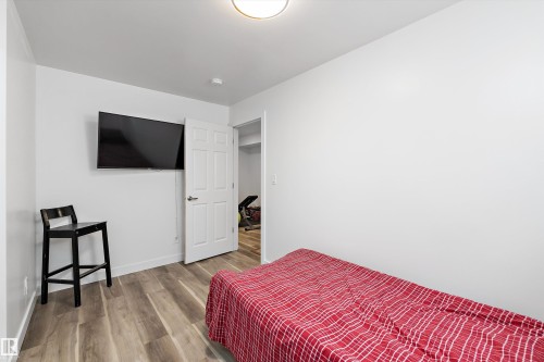 Room featuring neutral white walls, wood-finish flooring, and a white six-panel door - 25 Halladay Boulevard, Spruce Grove, AB - Indoor Photo Showing Bedroom