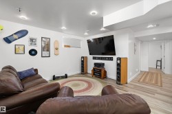 Spacious entertainment area with recessed lighting, light wood-finish flooring, and crisp white walls - 