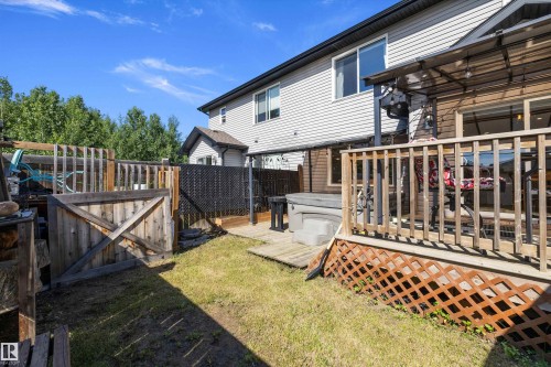 Rear exterior featuring a wooden deck with lattice skirting, an integrated spa, and a privacy fence - 25 Halladay Boulevard, Spruce Grove, AB - Outdoor With Deck Patio Veranda With Exterior