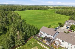 Aerial perspective showcasing residential properties bordering a verdant expanse of natural landscape - 