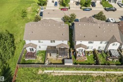 Aerial perspective showcasing two properties with fenced backyards - 