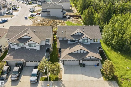 Exterior featuring multi-dormer rooflines, light gray siding, white trim accents, and attached garages - 25 Halladay Boulevard, Spruce Grove, AB - Outdoor