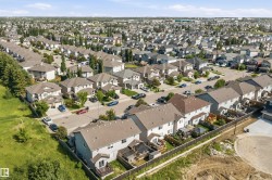 An aerial perspective reveals a residential neighborhood with a variety of detached homes featuring shingle roofing - 