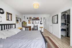 Spacious room featuring light vinyl plank flooring, a contemporary ceiling light fixture, and a built-in closet with wire shelving - 