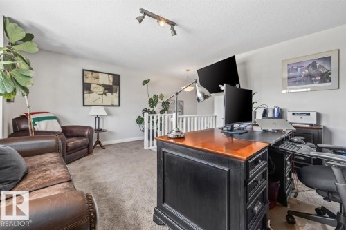 Carpeted bonus room featuring a partial railing, track lighting, and soft wall tones - 14 Edinburgh Crt N, St. Albert, AB 