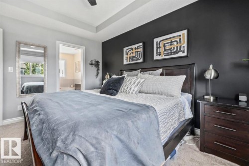 Carpeted bedroom featuring a tray ceiling and a dark accent wall - 14 Edinburgh Crt N, St. Albert, AB 