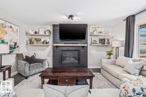 Living area featuring a central fireplace with dark shiplap detailing and a wood mantel - 14 Edinburgh Crt N, St. Albert, AB 