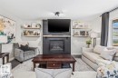 Living area featuring a central fireplace with dark shiplap detailing and a wood mantel - 14 Edinburgh Crt N, St. Albert, AB 