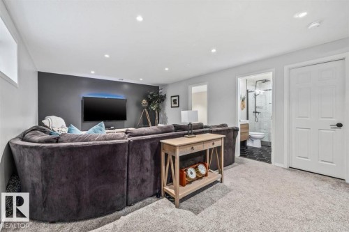 Spacious recreation area featuring recessed lighting, a dark accent wall, and light-toned carpet flooring - 14 Edinburgh Crt N, St. Albert, AB 