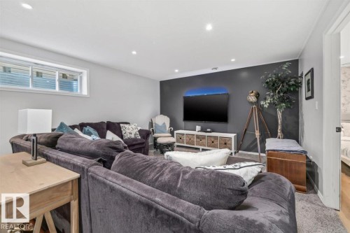 Spacious recreation room featuring recessed lighting, a window, and a built-in media console - 14 Edinburgh Crt N, St. Albert, AB 
